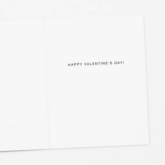 Inside fold of a Valentine's Day Greeting Card. White background features a single line greeting: “HAPPY VALENTINE'S DAY!" in uppercase block letters on the right side fold of the card.