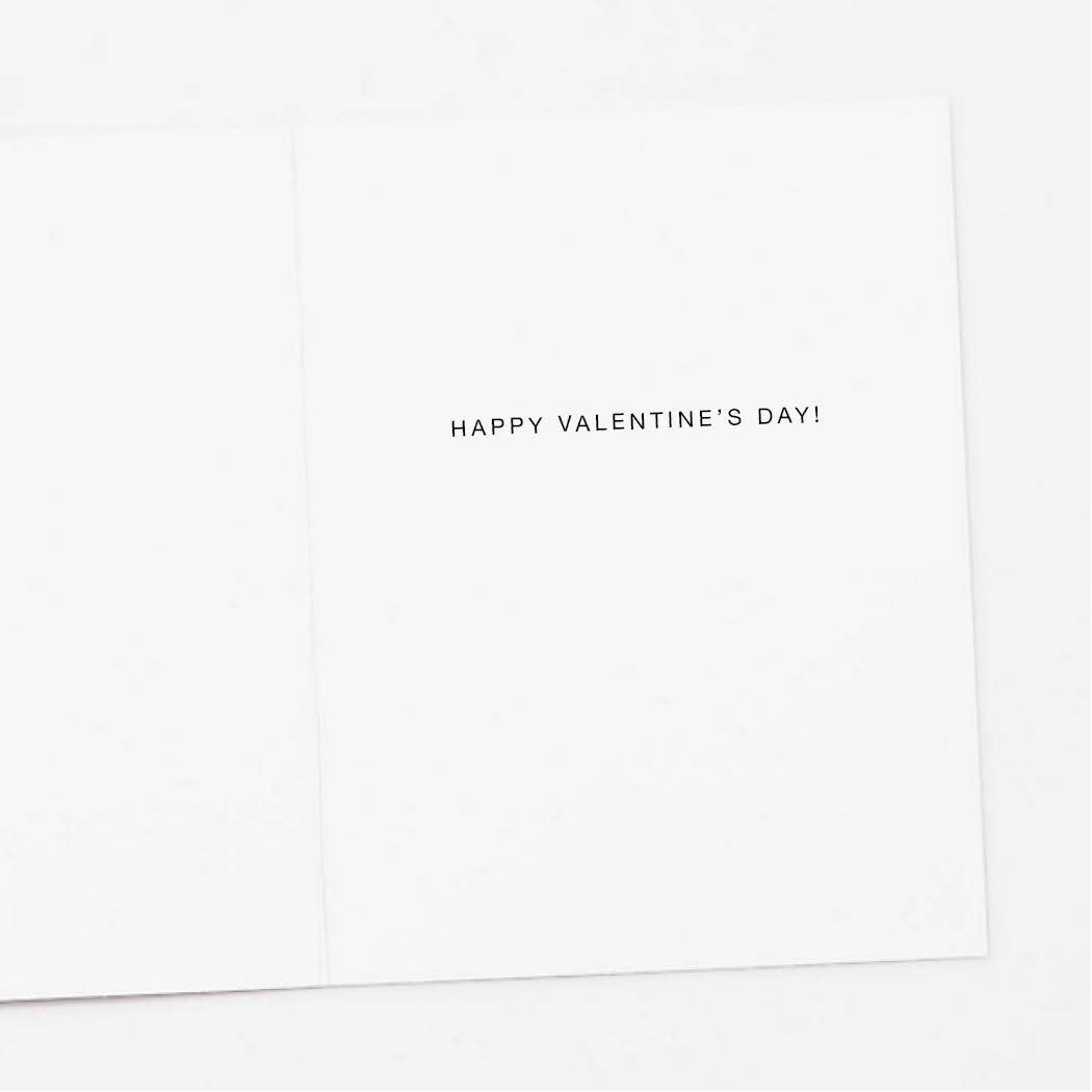 Inside fold of a Valentine's Day Greeting Card. White background features a single line greeting: “HAPPY VALENTINE'S DAY!" in uppercase block letters on the right side fold of the card.